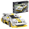 Model car built from interlocking bricks with Opel branding, next to its packaging.
